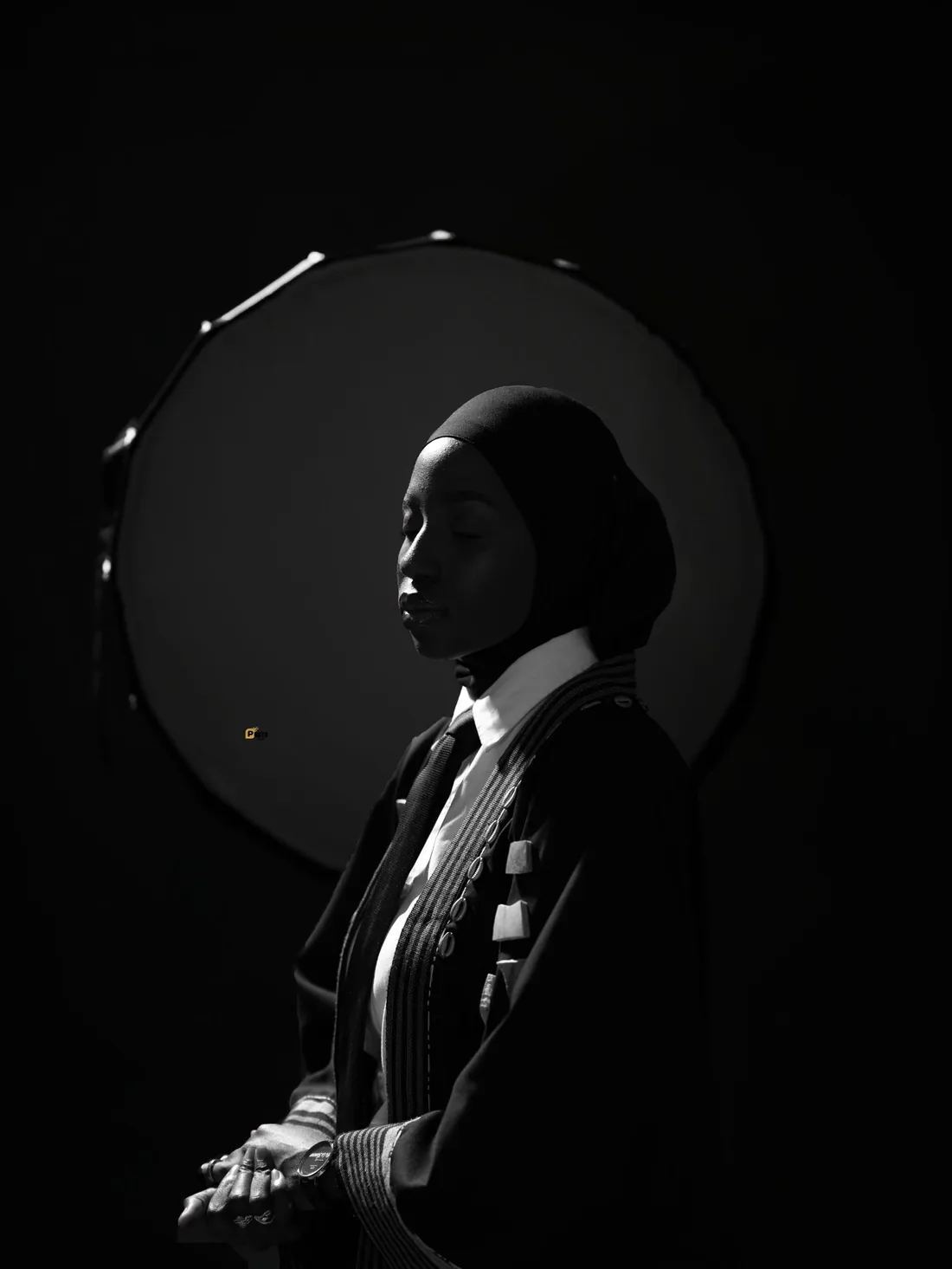 Portrait noir et blanc de Fa la Slameuse, les yeux clos, devant un disque de lumière
